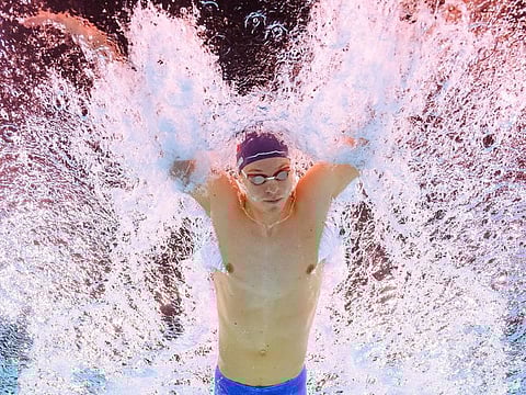 An underwater view shows Frances Leon Marchand competing in the heats of the men's 200m individual medley swimming event during the Paris 2024 Olympic Games at the Paris La Defense Arena in Nanterre, west of Paris on August 1, 2024. (Photo by Manan VATSYAYANA / AFP)