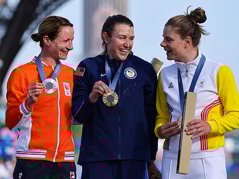 Silver medallist Netherlands' Marianne Vos (from left), gold medallist US' Kristen Faulkner and bronze medallist Belgium's Lotte Kopecky celebrate on the podium during the medal ceremony for the women's cycling road race during the Paris 2024 Olympic Games in Paris, on Sunday.