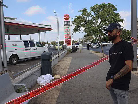 A man stands outside the cordoned off area where a reported stabbing attack took place in Holon in the southern suburb of Tel Aviv on August 4, 2024.