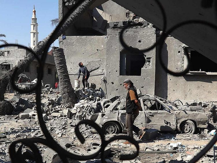 A Palestinian man walks past destruction in Deir El balah in the central Gaza Strip, on August 7, 2024, following Israeli bombardment. 