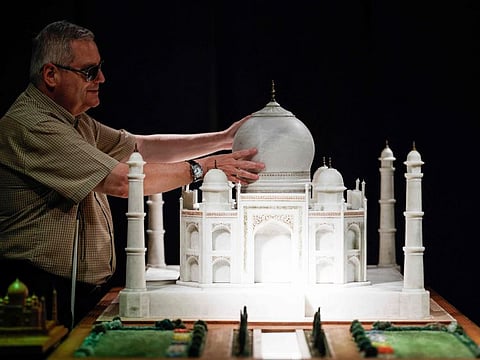 Visually impaired Jose Pedro Gonzalez touches the model of the Taj Mahal with his hands in Madrid on August 05, 2024. 