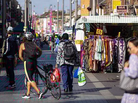 Pedestrians pass market stalls in Walthamstow, London, on August 8, 2024.  