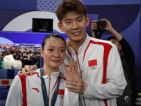China's gold medallist Huang Ya Qiong poses with her engagement ring after accepting a marriage proposal from her partner Liu Yuchen after mixed doubles final in Paris.