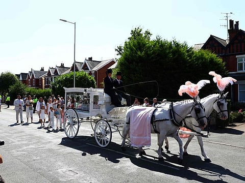 The coffin of nine-year-old Alice Dasilva Aguiar is carried by horse-drawn carriage as it arrives for her funeral service at St Patrick's Catholic Church in Southport, northwest England, on August 11, 2024.  