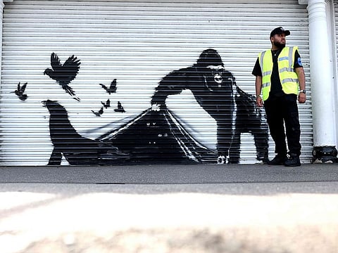An artwork by street artist Banksy, the ninth to released in nine days, depicts a gorilla releasing animals, on the front of a shutter outside London zoo, on August 13, 2024.