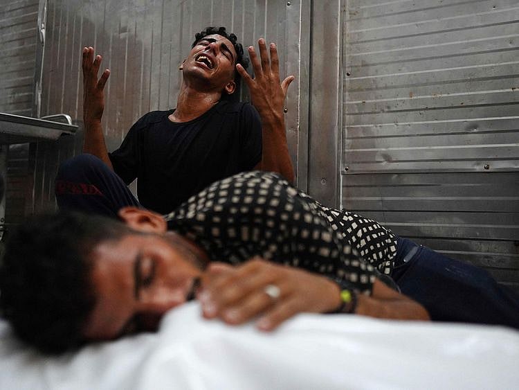 Palestinians mourn over a body of a relative, killed in an Israeli strike, ahead of their funeral in Khan Yunis in the southern Gaza Strip on August 12, 2024.