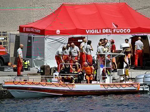 Divers of the Vigili del Fuoco, the Italian Corps. of Firefighters, return to Porticello on a small boat, on August 20, 2024 near Palermo a day after the British-flagged luxury yacht Bayesian sank.  