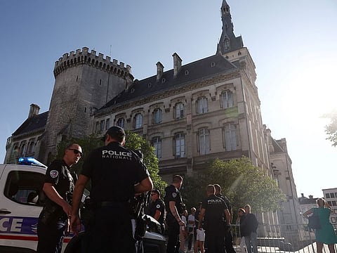 French police stand guard in front of the Town Hall after a man attempted to set the building alight with petrol in Angouleme on August 21, 2024. 