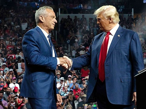 Former Republican presidential candidate Robert F. Kennedy Jr. and Republican presidential nominee, former US President Donald Trump shake hands during a campaign rally at Desert Diamond Arena on August 23, 2024 in Glendale, Arizona. 