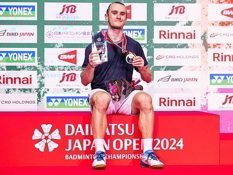 Gold medallist Frances Alex Lanier poses on the podium after his victory against Taiwan's Chou Tien-chen in their men's singles final of the Japan Open badminton tournament at Yokohama Arena, south of Tokyo on Sunday.