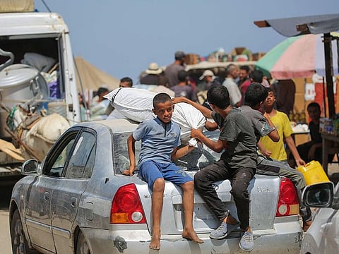 Displaced Palestinians leave the perimeter of the Al-Aqsa Martyrs Hospital in Deir al-Balah in the central Gaza Strip following renewed Israeli evacuation orders for the area.