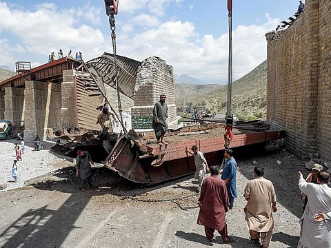 Railway workers clear the wreckage of a collapsed bridge the morning after a blast by militants at Kolpur in Bolan district, Balochistan province on August 27, 2024.  