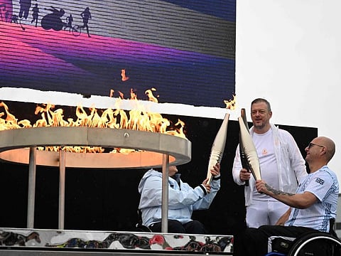Britain's Helene Raynsford, and Gregor Ewan, light the torch of President of the International Paralympic Committee Andrew Parsons, lit from the cauldron, during the Paralympic torch-lighting ceremony at Stoke Mandeville in Aylesbury, central England on August 24.