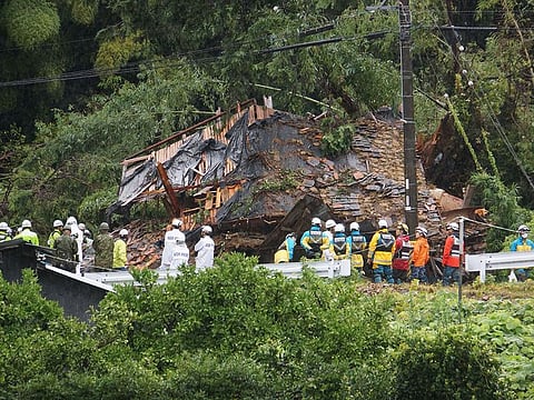 This photo shows rescue workers outside a house that was hit by a landslide in Gamagori, Aichi prefecture on August 28, 2024. 