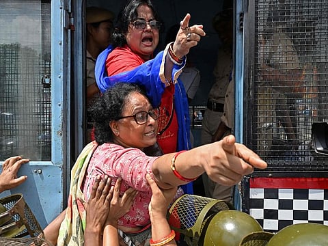 Activists of the Bharatiya Janata Party (BJP) shout slogans after being detained by police during a protest rally, in Kolkata on August 28, 2024.  