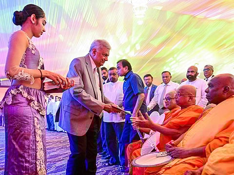 Sri Lanka's President and independent presidential candidate Ranil Wickremesinghe distributes copies of his election manifesto to Buddhist monks, in Colombo on August 29, 2024. 