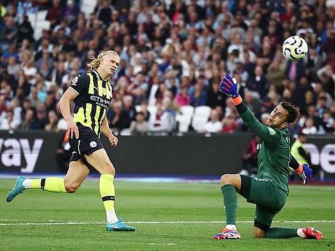 Manchester City's Erling Haaland (L) scores his third goal past West Ham United's goalkeeper Lukasz Fabianski during the English Premier League football match at the London Stadium, in London on August 31, 2024. 
