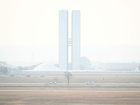The National Congress is seen shrouded in smoke caused by forest fires, in Brasilia, Brazil.