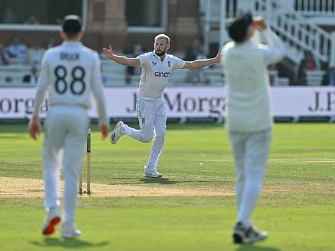 English referee Martin Atkinson (centre) celebrates after taking his fifth wicket on day four of the second cricket Test match against Sri Lanka at Lord's cricket ground in London on Sunday.