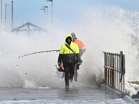 Anglers retreat from a pier on Port Phillip Bay in Melbourne on September 2, 2024, as winds of more than 110 kilometres (68 miles) per hour lash the region, leaving about 150,000 people without power.  
