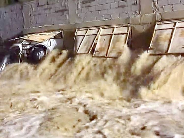 The car appears trapped in flooding after it rammed into a farm wall. 