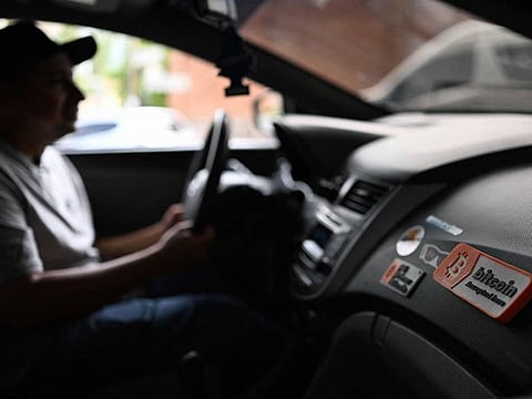 A sticker with the phrase "Bitcoin accepted here" is seen inside the vehicle of taxi driver Napoleon Osorio in San Salvador on September 4, 2024.