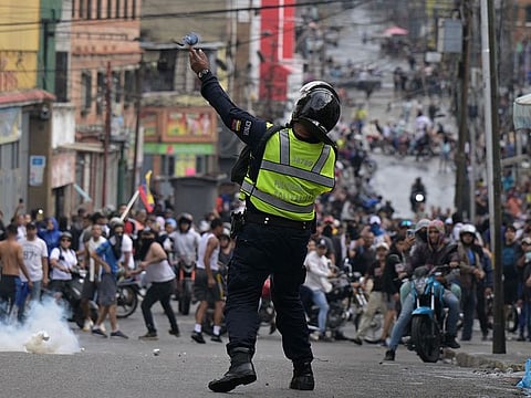 A riot police officer uses tear gas against demonstrators during a protest by opponents of Venezuelan President Nicolas Maduro's government in the Catia neighborhood of Caracas.