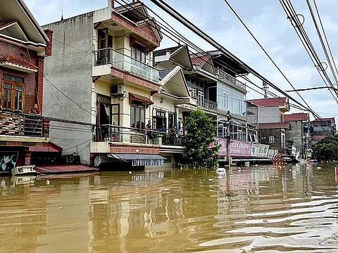 People stand on their balcony above a flooded street in Trang Dinh district, Lang Son province, on September 9, 2024, after Typhoon Yagi swept through northern Vietnam. 