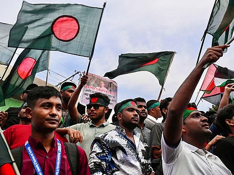 Demonstrators wave Bangladesh's national flag during Martyr March, a rally organised by Students Against Discrimination to mark one month to the ousting of the country's former Prime Minister Sheikh Hasina, in Dhaka on September 5, 2024. 