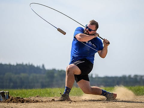 A hornusser reacts after hitting the "nouss" puck during a hornussen game at the 40th Swiss Hornussen Festival in Hoechstetten, August 31, 2024. 