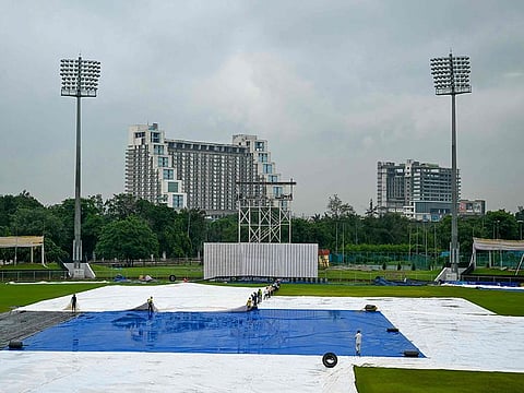Groundsmen remove the field's cover after the one-off Test cricket match between Afghanistan and New Zealand was called off, at the Shaheed Vijay Singh Pathik Sports Complex in Greater Noida on September 13, 2024. 