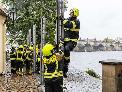 Firefighters build anti-flood barriers on the left bank of the Vlatva river, near the Charles Bridge in Prague on September 13, 2024. 