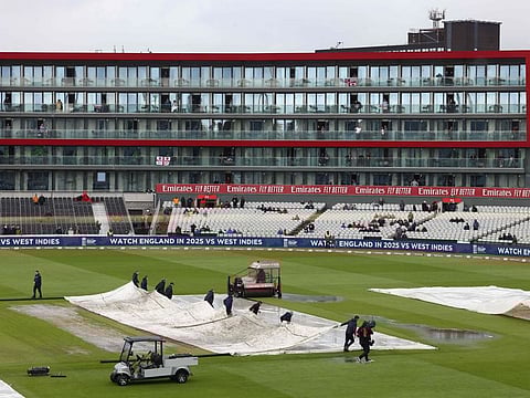 Covers are spread out due to rain during the 3rd Twenty20 International cricket match between England and Australia at Old Trafford, in Manchester, on Sunday.