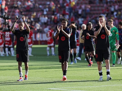 Barcelona's Brazilian forward Raphinha, Spanish forward Lamine Yamal and Polish forward Robert Lewandowski applaud at the end of the Spanish league football match against Girona FC at the Montilivi stadium in Girona on Sunday.