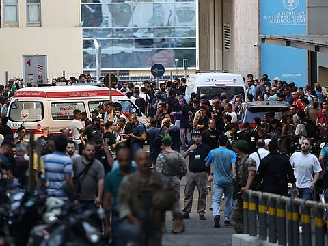 Ambulances are surrounded by people at the entrance of the American University of Beirut Medical Center.