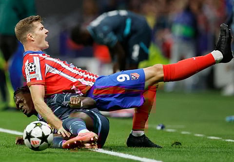 Atletico Madrid's Norwegian forward Alexander Sorloth falls down over RB Leipzig's French defender Castello Lukeba during the Uefa Champions League 1st round football match at the Metropolitano stadium in Madrid on September 19.