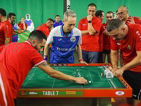 People watch the match as a player from Malta (L) prepares to take a shot against Belgium during the Subbuteo World Cup in Tunbridge Wells in south east England, on September 22, 2024. 