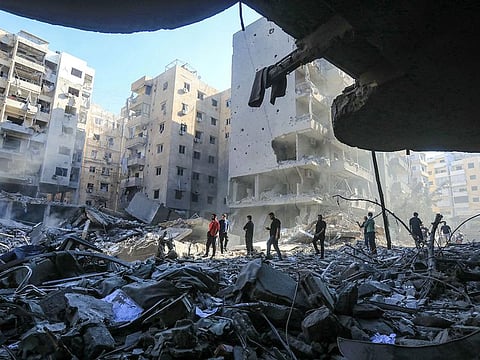 People walk amid the rubble of buildings which were levelled by Israeli strikes that targeted and killed Hezbollah leader Hassan Nasrallah in the Haret Hreik neighbourhood of Beirut's southern suburbs on September 29, 2024.