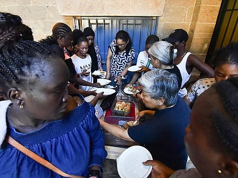 Migrant workers queue for a meal at the Saint Joseph Jesuites Fathers Church, that was turned into a shelter to house families fleeing their homes as a result of Israeli attacks, in Lebanon's capital Beirut on September 29, 2024.  