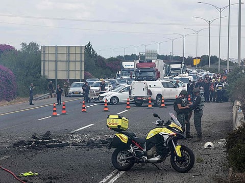 Israeli emergency and security personnel deploy at the impact site of a reported rocket fired from Lebanon, on the Horeshim interchange in central Israel on October 1, 2024. 