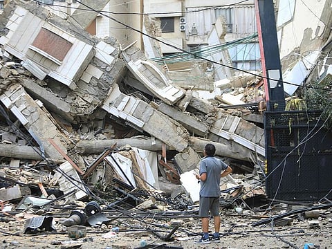 A man looks at the destruction at the site of an overnight Israeli airstrike on the Ruwais neighbourhood in Beirut's southern suburbs on October 1, 2024. 