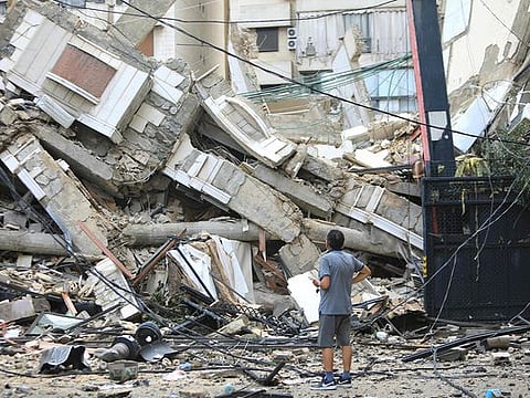 A man looks at the destruction at the site of an overnight Israeli airstrike on the Ruwais neighbourhood in Beirut's southern suburbs on October 1, 2024. 