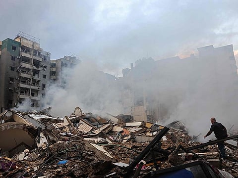 A man walks on building rubble at the site of an overnight Israeli airstrike on the Laylaki neighbourhood in Beirut's southern suburbs on October 1, 2024. 
