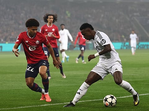 Real Madrid's Brazilian forward Vinicius Junior (right) is challenged by Lille's Portuguese defender Tiago Santos during the Uefa Champions League football match at the Pierre Mauroy Stadium in Villeneuve-d'Ascq, northern France, on Tuesday.