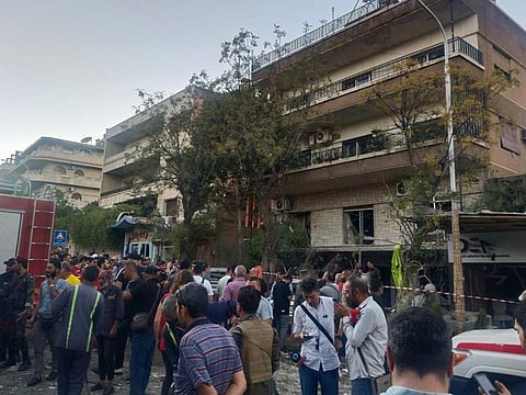 Emergency service personnel and residents gather at the site of an Israeli strike in Syria's capital Damascus on October 2, 2024.  