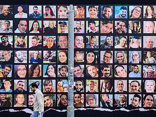 File photo: A man walks past a giant billboard featuring portraits of Israeli hostages held in Gaza since the October 7 attack by Hamas militants, in Jerusalem on November 25, 2023.  
