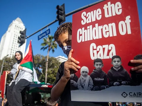 A young protestor holds a sign reading "Save the Children of Gaza" as people demonstrate to mark one year of the war between Hamas and Israel in Los Angeles, on October 5, 2024.