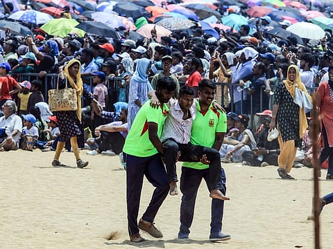 Fire and Rescue Service personnel evacuate a man after he fainted due to heat during the Indian Air Force (IAF) airshow as part of the 92nd anniversary celebrations of IAF, at Marina Beach in Chennai on Sunday.  