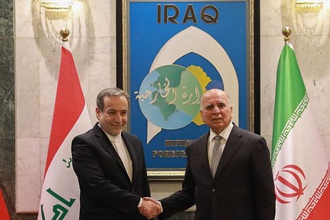 Iraqi Foreign Minister Fuad Hussain (right) welcomes his Iranian counterpart Abbas Araghchi in Baghdad on October 13, 2024. 