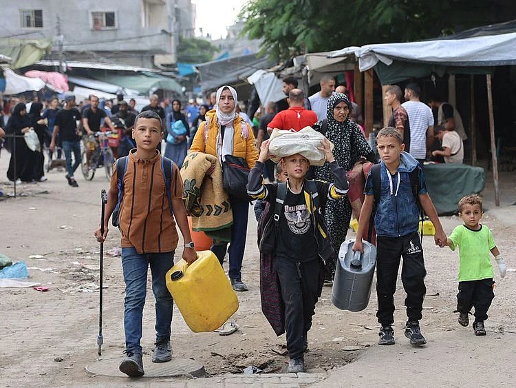 Palestinian families arrive in Gaza City after evacuating their homes in the Jabalia area.